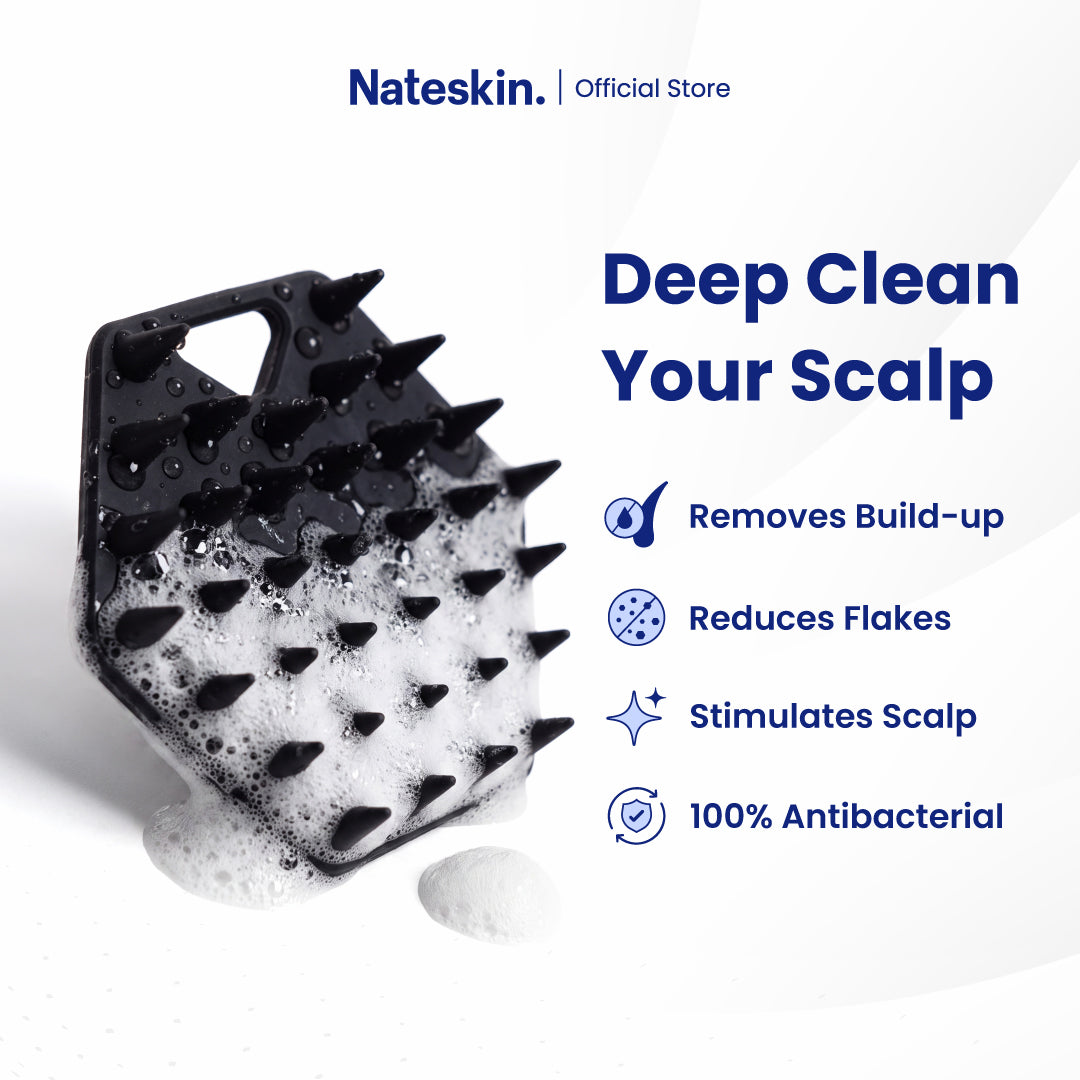 Nateskin black silicone scalp scrubber with spiky bristles, shown covered in white foam on a clean white background with promotional text listing benefits like removing build-up, reducing flakes, stimulating scalp, and 100% antibacterial.